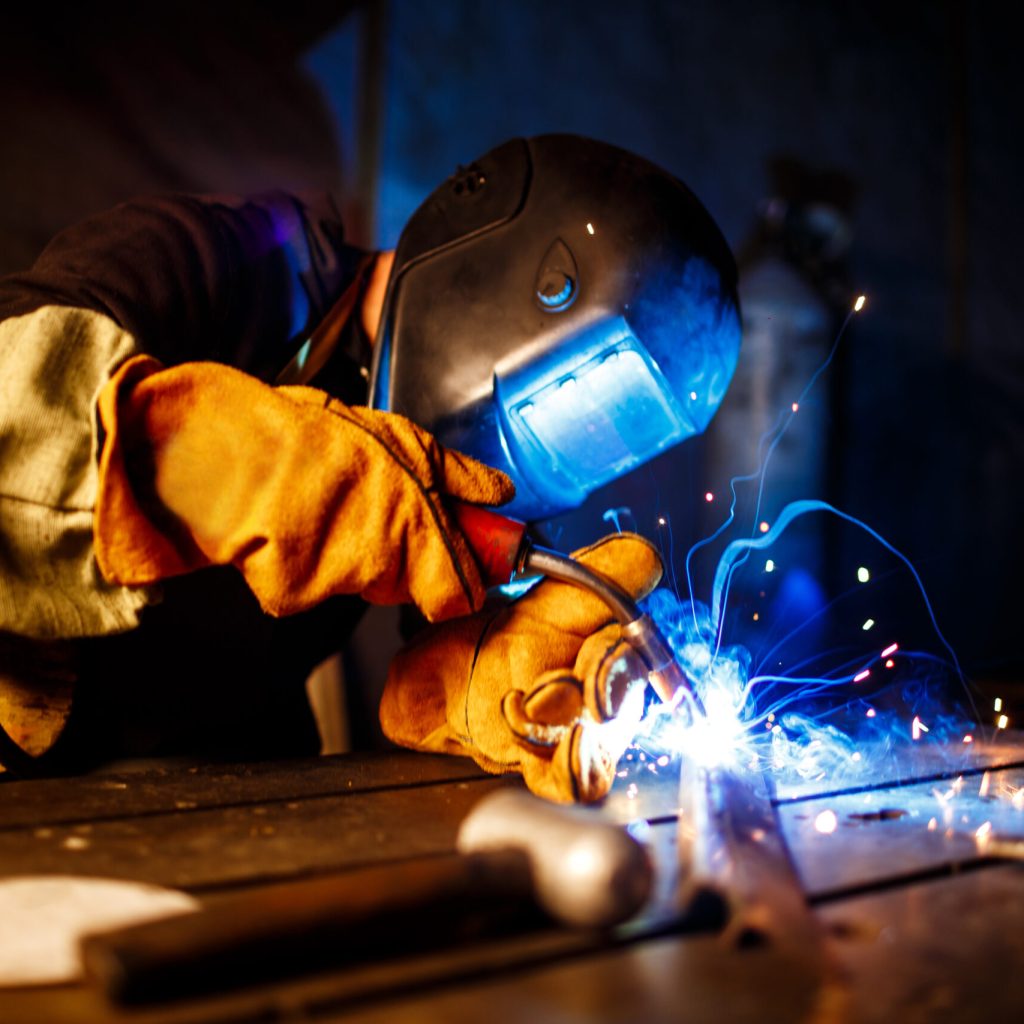 Worker cutting metal with plasma equipment. on plant